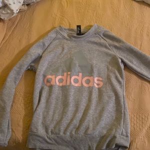 A grey adidas crew neck with pink letters in the size S